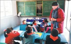  ?? PHOTOS BY WANG JIAN / CHINA DAILY ?? Zhi Yueying gives a Chinese lesson to students at the primary school in Baiyang, Fengxin county, in Jiangxi province.