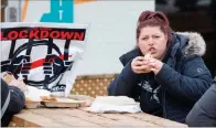  ?? (AFP) ?? A woman eats on the patio of Adamson Barbecue, an Etobicoke business that has defied provincial shutdown orders, in Toronto on Wednesday.