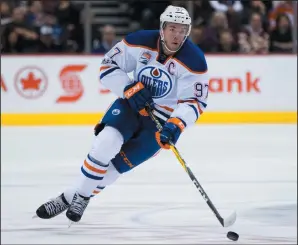  ?? DARRYL DYCK/THE CANADIAN PRESS VIA AP, FILE ?? FILE - In this April 8, 2017, file photo, Edmonton Oilers' Connor McDavid skates with the puck against the Vancouver Canucks during the first period of an NHL hockey game, in Vancouver, British Columbia. The Oilers have signed star captain Connor...