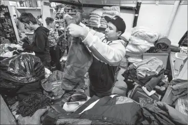  ?? Herald photo by Ian Martens ?? Volunteer Will Cross Child sorts through jackets and other items of clothing in the sorting area of the People In Need (P.I.N.) Bank at Streets Alive Mission. The agency is in need of donations of winter clothing leading into the season. @IMartensHe­rald