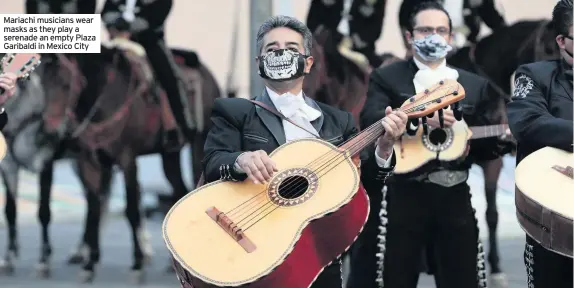  ??  ?? Mariachi musicians wear masks as they play a serenade an empty Plaza Garibaldi in Mexico City