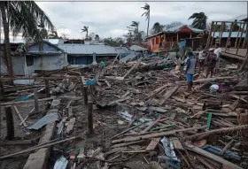  ?? CARLOS HERRERA — BLOOMBERG ?? Residents inspect destroyed houses in the coastal neighborho­od of El Muelle after Hurricane Iota made landfall in Bilwi, Nicaragua, on Nov. 20, 2020.