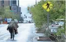  ?? MEGAN MENDOZA/USA TODAY NETWORK ?? A cyclist rides through downtown Phoenix in a rain poncho Sunday.