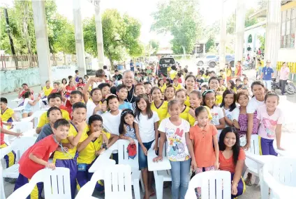 ?? SUNSTAR FOTO / ALLAN DEFENSOR ?? BENEFICIAR­IES. Cebu Gov. Hilario Davide III poses with the pupils of Alegria Central Elementary School, which received 150 plastic armchairs from the Cebu Provincial Government. Some eight barangays in the town will also benefit from a water system...