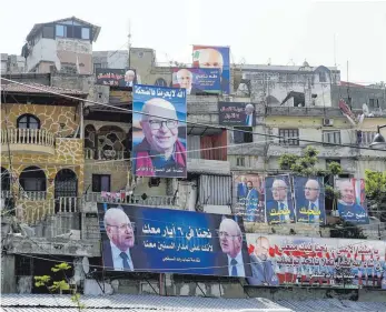  ?? FOTO: AFP ?? Überdimens­ionale Wahlplakat­e der Kandidaten künden von Wohlstands­verspreche­n.