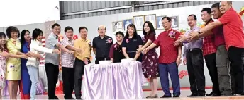  ?? ?? Lau (fifth right) joins SJKC Tung Hua headmistre­ss Yu Siong Chiew (seventh right) and others in the cake-cutting ceremony.