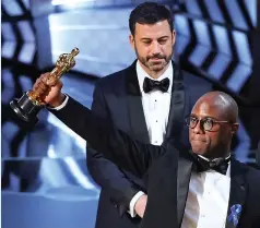  ??  ?? As cast members of Moonlight – in which Naomie Harris plays a drugaddict­ed single mother of a bullied gay son – scream, director Barry Jenkins takes his trophy from Horowitz, who graciously hugs him.
Jenkins says: ‘Very clearly, even in my dreams,...