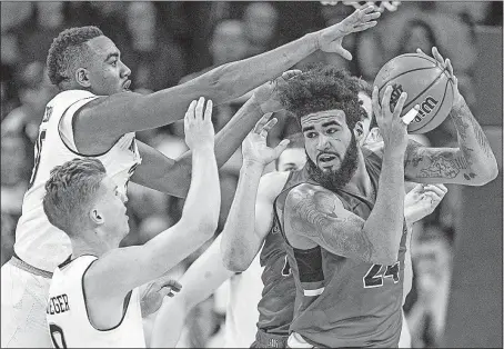  ?? [ROBERT FRANKLIN/THE ASSOCIATED PRESS] ?? Ball State’s Trey Moses gets pressure from Notre Dame’s Bonzie Colson, left, and Rex Pflueger during the second half in South Bend, Ind. Ball State won 80-77. NO. 18 WEST VIRGINIA 68, NO. 15 VIRGINIA 61: TEXAS TECH 82, NO. 22 NEVADA 76: