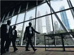  ??  ?? People walk against the background of Petronas Twin Towers at the 20th Asia Oil & Gas Conference in Kuala Lumpur.