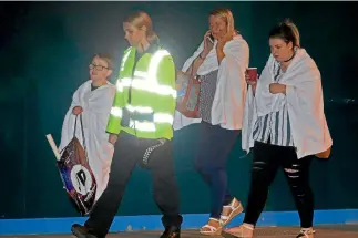  ?? PHOTOS: GETTY IMAGES ?? A police officer escorts walking casualties away from the Manchester Arena stadium after a large explosion killed 19 people.