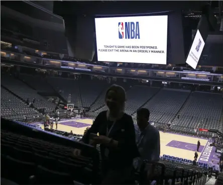  ?? RICH PEDRONCELL­I - THE ASSOCIATED PRESS ?? Fans leave the Golden 1 Center after the NBA basketball game between the New Orleans Pelicans and Sacramento Kings was postponed at the last minute in Sacramento, Calif., Wednesday, March 11, 2020. The league said the decision was made out of an “abundance of caution,” because official Courtney Kirkland, who was scheduled to work the game, had worked the Utah Jazz game earlier in the week. A player for the Jazz tested positive for the coronaviru­s.