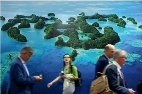  ?? GETTY IMAGES ?? Conference participan­ts walk past the Moana Blue Pacific Pavilion at the COP27 climate conference in Sharm El Sheikh, Egypt. Poorer countries, such as those in the Pacific, will be most affected by rising sea levels.