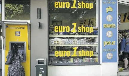  ?? ?? A woman uses an ATM machine in the main town of the Aegean Sea island of Rhodes, south-eastern Greece, Tuesday, May 10, 2022. Inflation in 19 European countries using the euro currency hits another record at 10 per cent as energy prices soar.