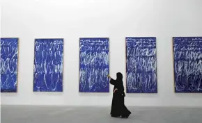  ??  ?? A visitor takes a photo of panels by American artist Cy Twombly