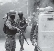  ?? CESAR FUENTES ?? A Honduran military police officer readies his M4-style rifle as security officers clash with protesters in January 2018. The photo was taken by human rights observer César Fuentes