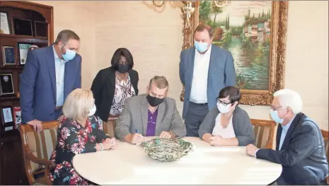  ?? Doug Walker ?? Synovus Bank Northwest Georgia Division market President Scott Preston (seated second from left) is flanked by Rome bank executives as they receive reports showing the bank now leads the Floyd County market in deposits.