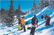  ?? Will Ford, for The Washington Post ?? Students look on in the afternoon as Tico Allulee of Colorado’s Kling Mountain Guides demonstrat­es how to dig a snow pit to analyze snowpack, which can help diagnose unstable snow layers.