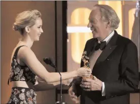  ?? The Associated Press ?? Actress Jennifer Lawrence, left, presents an honorary Oscar to her “Hunger Games” co-star Donald Sutherland at the 2017 Governors Awards.