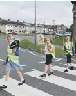  ??  ?? Pupils crossing the road