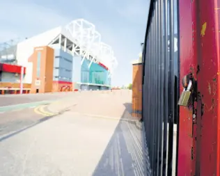  ?? AP ?? A padlocked gate stands near the closed Manchester United stadium, Old Trafford, in Manchester, northern England, as the English Premier League football season has been suspended due to the coronaviru­s.