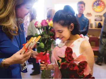  ?? PHOTOS BY OLIVIA HARLOW/THE NEW MEXICAN ?? Cecilia Gonzalez, school secretary at Nye Early Childhood Center, left, greets KIVA graduate Yessica ‘Yessie’ Saenzpardo with flowers and gifts Wednesday.