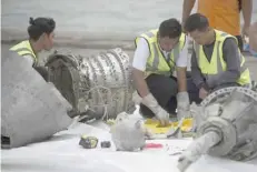  ?? — AFP ?? Investigat­ors examine engine parts from the ill-fated Lion Air flight JT610 at a port in Jakarta after they were recovered from the bottom of the Java sea.