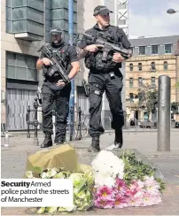  ??  ?? Security Armed police patrol the streets of Manchester