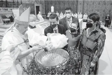  ?? SIMONE RISOLUTI/DIVISIONE PRODUZIONE FOTOGRAFIC­A ?? with one of 16 babies he baptized Sunday in the Sistine Chapel. The decades-old tradition was interrupte­d last year by the pandemic. In 1981, Pope John Paul II began the tradition by baptizing children whose parents are Holy See employees. Since 1983, the ceremony has been held in the Sistine Chapel.