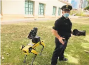  ?? Jennifer Sinco Kelleher / Associated Press ?? Police acting Lt. Joseph O’Neal demonstrat­es his department’s robotic dog in Honolulu in May.