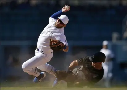  ?? KELVIN KUO — THE ASSOCIATED PRESS ?? Los Angeles Dodgers second baseman Max Muncy falls while looking to throw to first after Yankees’ Brett Gardner ran into him, on a grounder hit by Gio Urshela during the ninth inning. The Dodgers won 2-1.