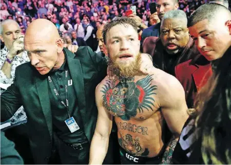  ?? AP ?? Der Fighter Conor McGregor wurde von gegnerisch­en Fans attackiert und danach aus der Arena in Las Vegas eskortiert.