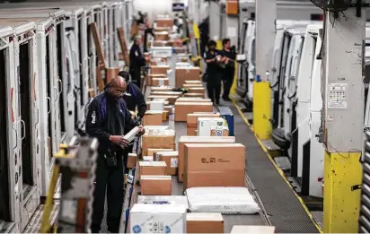  ?? Christophe­r Dilts / Bloomberg ?? Employees sort packages for delivery on Monday at a FedEx shipping center in Chicago amid growth in online shopping.