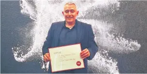  ??  ?? ●● Ilian Iliev with one of his certificat­es at the Gourmand World Cookbook Awards in China