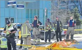  ?? REUTERS ?? ■ Fire fighters stand near a covered body at a major intersecti­on in Toronto on Monday.