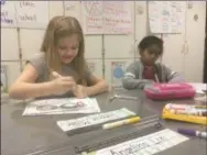  ?? ZACHARY SRNIS — THE MORNING JOURNAL ?? Cameron Miller, left, and Christina Matthews, both 8-yearold second graders at Avon East Elementary School, work on a project of “100” glasses.