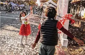  ?? Stephen Lam/The Chronicle ?? Five-year-old Frances Claire enjoys artificial snow at the San Rafael festival.