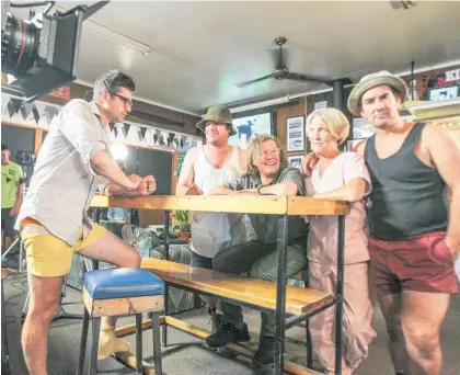  ??  ?? On the set of the film This Town at the Patangata Pub, Waipawa, director David White talks with cast members Jason Hoyte, Robyn Malcolm, Juliette Hamilton and Jonny Brough.