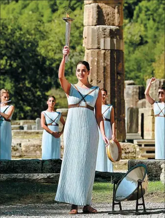  ?? ARIS MESSINIS / AFP ?? Greek actress Xanthi Georgiou, playing the role of the high priestess, holds the lit torch during the flame lighting ceremony on Monday for the Beijing 2022 Winter Olympics at the Ancient Olympia archaeolog­ical site, the birthplace of the ancient Olympics, in southern Greece.