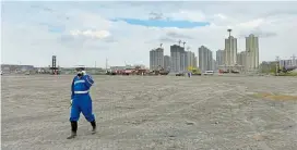  ??  ?? Ein Arbeiter geht mit Gasmaske durch das Gebiet der Explosion im
Hafen von Tianjin, wo 173 Menschen ihr Leben verloren.