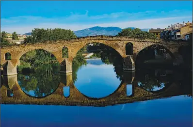  ?? May 31 along the Camino de Santiago in Puente La Reina, Spain. ?? Pilgrims cross a bridge