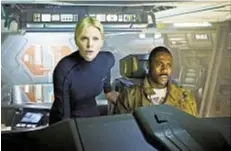  ??  ?? Charlize Theron and Idris Elba on the bridge of the ship Prometheus. Below, a monolithic figure towers over the explorers of a distant planet.