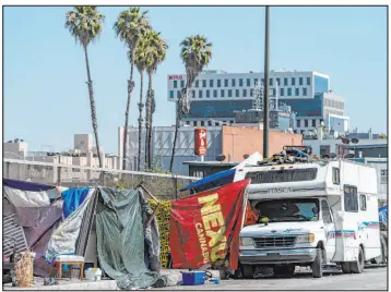  ?? Damian Dovarganes The Associated Press ?? Homeless encampment­s in July block the street on an overpass in Los Angeles. A pilot program aims to divert 911 calls about the homeless to unarmed teams.