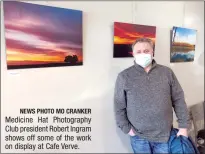  ?? NEWS PHOTO MO CRANKER ?? Medicine Hat Photograph­y Club president Robert Ingram shows off some of the work on display at Cafe Verve.