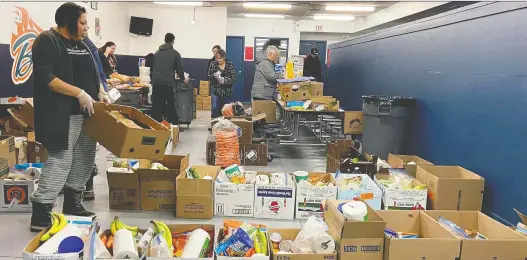  ??  ?? Volunteers at the Turnor Lake and Birch Narrows Community Food Centre, in the community about 580 kilometres north of Saskatoon, prepare food packages to be delivered to local families.