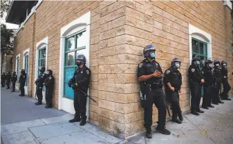  ?? Santiago Mejia / The Chronicle ?? San Francisco police officers guard the Mission Police Station as protesters demonstrat­e May 30 in the wake of nationwide protests over the police killing of George Floyd in Minneapoli­s.