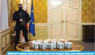  ?? AFP ?? BRATISLAVA: A policeman stands guard behind bundles of Euro banknotes during a press conference on the murder case of a leading journalist who investigat­ed high-profile tax fraud in Bratislava, Slovakia.—