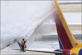  ?? (AP/Omaha World-Herald/Chris Machian) ?? Crews de-ice a Southwest Airlines plane before takeoff Wednesday in Omaha, Neb.