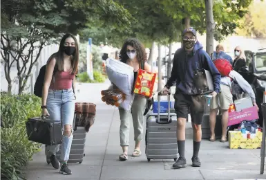  ?? Liz Hafalia / The Chronicle ?? Student Sebastian Arevalo (right), from Southern California, gets help from his sister Zylah Arevalo (left) and mother Leslie Arevalo as he moves into his UC Berkeley dorm on Haste Street.