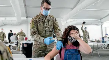  ?? AP ?? Leanne Montenegro, 21, who doesn’t like the sight of needles, covers her eyeswhile she receives the Pfizer Covid-19 vaccine at a vaccinatio­n centre at Miami Dade College. Any adult in Florida is now eligible to receive the coronaviru­s vaccine. Teens aged 16 and 17 can also get the vaccine with parental permission.