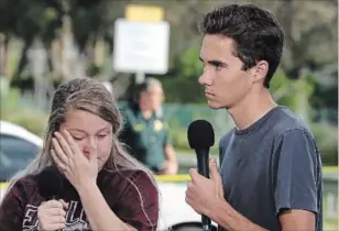  ?? MARK WILSON GETTY IMAGES ?? Students Kelsey Friend and David Hogg, right, recount their stories about the mass shooting at the high school where 17 people were killed on Feb. 15. Police arrested the suspect and former students at the school after a short manhunt.